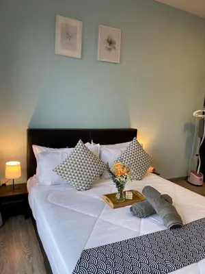 a bed with a tray with a vase of flowers on it at 7PAX Kepong DesaPark Publika MontKiara 100Mbps in Kuala Lumpur