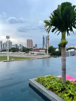 a palm tree in a pool with a city in the background at Opus Residences KL Merdeka 118 View in Kuala Lumpur
