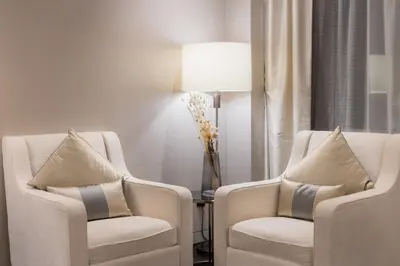 a room with two chairs and a table with a lamp at Bukit Bintang Signatures Pavilion Kuala Lumpur in Kuala Lumpur