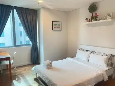 a bedroom with a white bed and a window at Mercu Summer Suite KLCC by Kuminshu in Kuala Lumpur