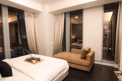 a bedroom with a bed and a chair and a window at Tropicana The Residences KLCC, Premium in Kuala Lumpur