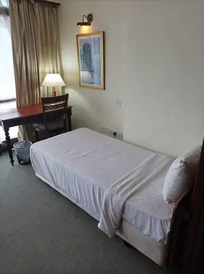 a bedroom with a bed and a desk and a piano at TM SUITE at BERJAYA TIME SQUARE KL in Kuala Lumpur