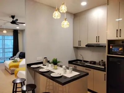 a kitchen and living room with a counter and a room with a bed at Bangsar Trade Center Studio 4pax I HomeBrickz in Kuala Lumpur