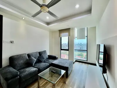 a living room with a black couch and a glass table at Casa Residency Service Apartment in Kuala Lumpur