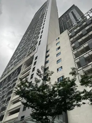 a tall building with a tree in front of it at The Colony KLCC view by NZV in Kuala Lumpur