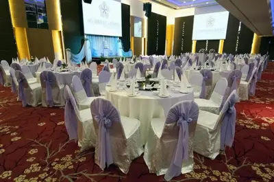a banquet hall with white tables and chairs with purple bows at Meta @ Swiss Garden Residence KL Bukit Bintang in Kuala Lumpur