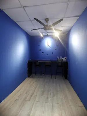 a blue room with a table and a clock on the wall at Blue house KL Homestay in Kuala Lumpur