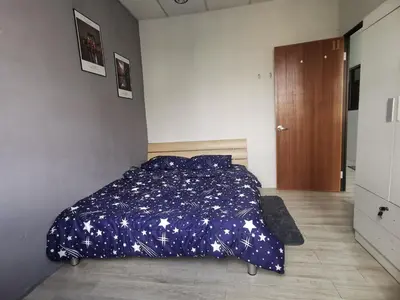a bedroom with a bed with a blue comforter with stars at Blue house KL Homestay in Kuala Lumpur