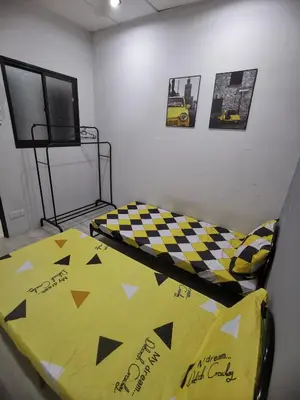 a bedroom with a bed with a yellow comforter at Blue house KL Homestay in Kuala Lumpur