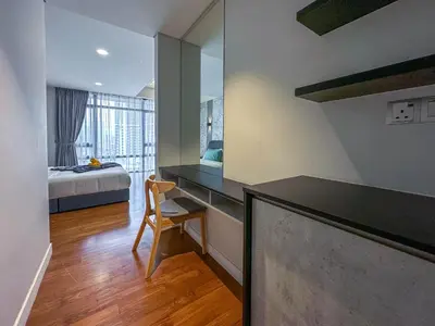 a room with a desk and a bedroom with a bed at Anggun Residence Serviced Suites By BedStay in Kuala Lumpur