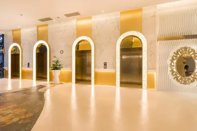 a lobby with yellow and white walls and gold doors at Arte Mont Kiara Hotel Suite in Kuala Lumpur