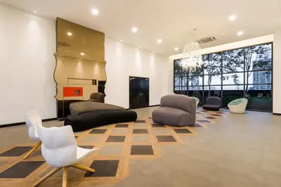 a living room with couches and chairs and a chandelier at Arte Mont Kiara Hotel Suite in Kuala Lumpur