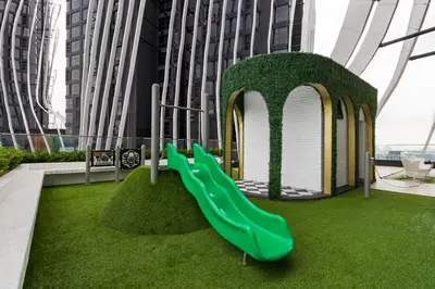 a playground with a green slide in a building at Arte Mont Kiara Hotel Suite in Kuala Lumpur