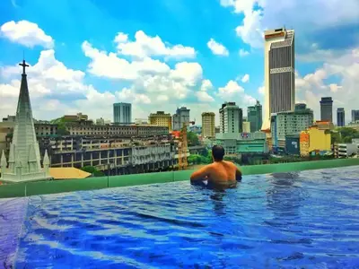 a man in a infinity pool overlooking a city at Meta @ Robertson KL Bukit Bintang in Kuala Lumpur