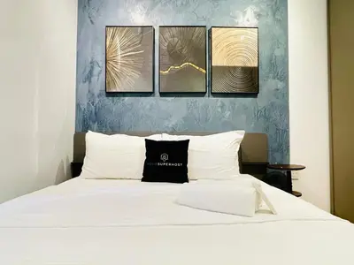 a bedroom with a bed with four paintings on the wall at EatonResidences KLCC by MAH in Kuala Lumpur