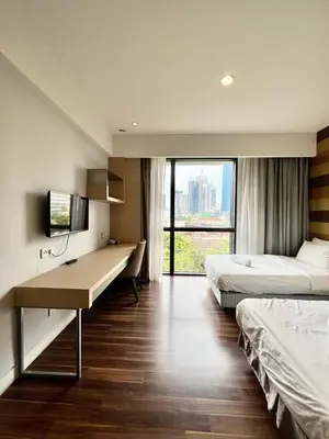 a hotel room with two beds and a desk in it at D'Majestic by Lush Living in Kuala Lumpur