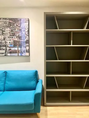 a living room with a blue couch and a book shelf at D'Majestic by Lush Living in Kuala Lumpur