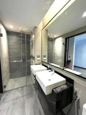 a bathroom with two sinks and a shower and a mirror at #173 M101 Dang Wangi KLCC View Pool By Livin in Kuala Lumpur