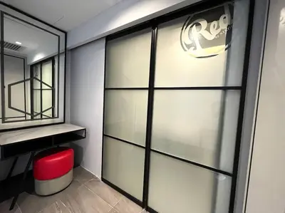 a bathroom with a sliding glass door with a red stool at #173 M101 Dang Wangi KLCC View Pool By Livin in Kuala Lumpur