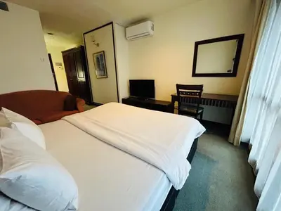 a hotel room with a bed and a chair at TWO BEDROOM SUITES at TIMES SQUARE KL in Kuala Lumpur