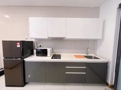 a kitchen with a black refrigerator and white cabinets at PROMO Connected Train 2 Bedroom ABOVE MALL 289 in Kuala Lumpur