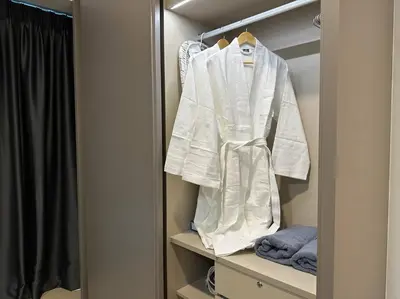 a white robe is hanging on a closet at Eaton Residences in Kuala Lumpur
