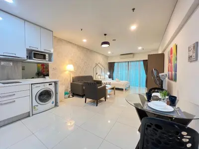 a kitchen and living room with a table and a living room at Mercu Summer Suites in Kuala Lumpur