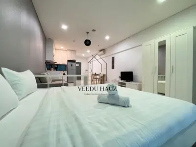 a large white bed in a room with a kitchen at Mercu Summer Suites in Kuala Lumpur