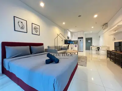 a bedroom with a bed with a blue stuffed animal on it at Mercu Summer Suites in Kuala Lumpur
