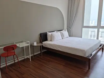 a bedroom with a bed and a red chair at Una Residence by Maya in Kuala Lumpur