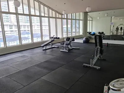 a gym with cardio equipment in a large room with windows at Una Residence by Maya in Kuala Lumpur