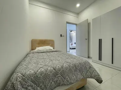 a bedroom with a bed in a white room at Bayu Andaman KL Centre in Kuala Lumpur