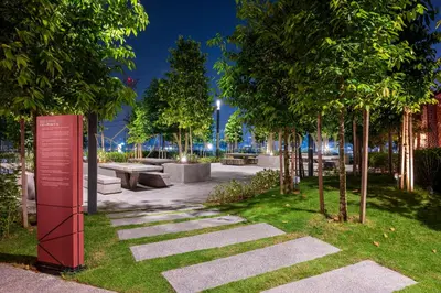 a park with benches and trees at night at M Vertica Premier Suites Kuala Lumpur in Kuala Lumpur