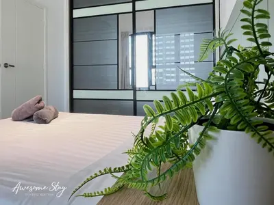 a bedroom with a bed and a large green plant at Arte Plus Ampang By Awesomestay in Kuala Lumpur