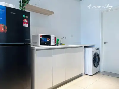 a kitchen with a counter with a microwave and a washing machine at Arte Plus Ampang By Awesomestay in Kuala Lumpur