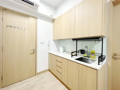 a kitchen with wooden cabinets and a sink at The Colony By Infinitum By Awesomestay in Kuala Lumpur