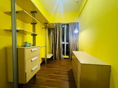 a yellow room with a desk and a window at Regalia Residence And Suites By The Relaxstay in Kuala Lumpur