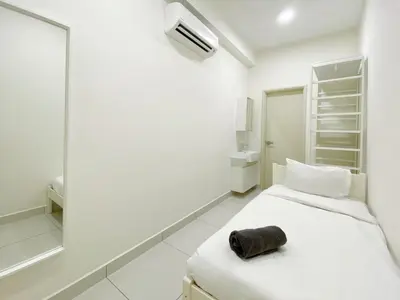 a white room with a bed and a mirror at Arte Mont Kiara By The Relaxstay in Kuala Lumpur