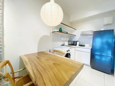 a kitchen with a wooden table and a blue refrigerator at Arte Mont Kiara By The Relaxstay in Kuala Lumpur