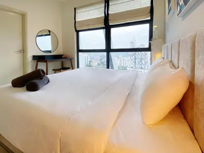 a bedroom with a large white bed with a window at Arte Mont Kiara By The Relaxstay in Kuala Lumpur