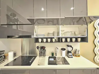a kitchen with white cabinets and a counter top at Lucentia Residence Bukit Bintang in Kuala Lumpur