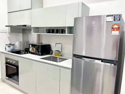 a stainless steel refrigerator in a white kitchen at Lucentia Residence Bukit Bintang in Kuala Lumpur