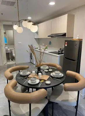 a kitchen with a table with chairs and a refrigerator at OOAK residence in Kuala Lumpur
