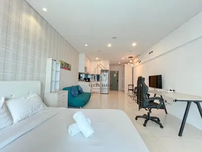 a bedroom with a white bed and a desk at Mercu Summer Suites KLCC by Veedu Hauz in Kuala Lumpur