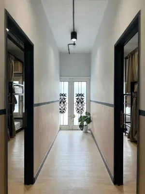a hallway with two doors and a potted plant at The Freedom Club Hostel KL in Kuala Lumpur