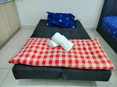 a blanket with a sock sitting on top of a bed at Ampang 2-4 pax Studio AmpPoint in Ampang