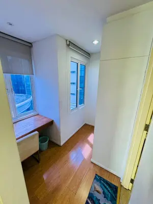 an empty room with a bench and two windows at Bintang Goldhill Guest House in Kuala Lumpur