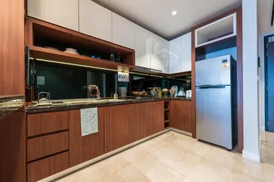 a kitchen with wooden cabinets and a refrigerator at Anggun Residences Luxury Suites KL City Center in Kuala Lumpur