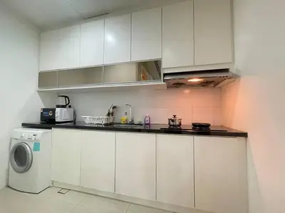 a kitchen with white cabinets and a washing machine at Binjai 8 Premium Soho, KLCC, nearby LRT by EC in Kuala Lumpur