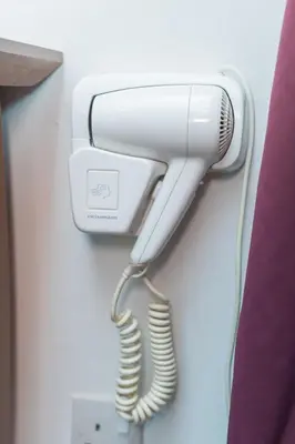 a hairdryer hanging on a wall at Menara PGRM By Minsu in Kuala Lumpur